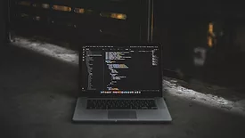 Laptop with coding on ground 