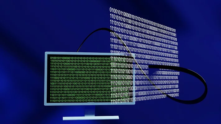 Computer with binary code hovering nearby 