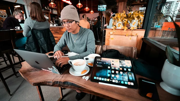 Young man working on laptop in coffee shop 