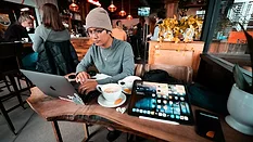 Young man working on laptop in coffee shop 