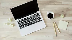 Laptop with crumbled papers