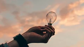 Hand holding lightbulb