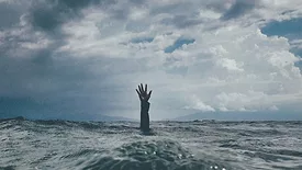 Hand reaching up out of the ocean