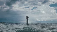 Hand reaching up out of the ocean Hand reaching up out of the ocean