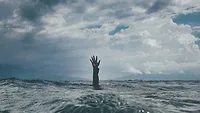 Hand reaching up out of the ocean Hand reaching up out of the ocean