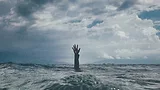 Hand reaching up out of the ocean