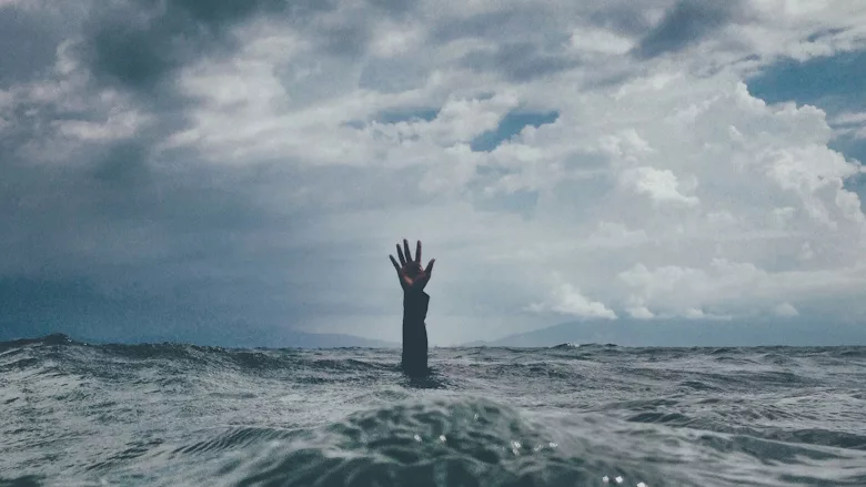 Hand reaching up out of the ocean