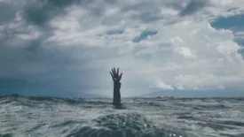 Hand reaching up out of the ocean