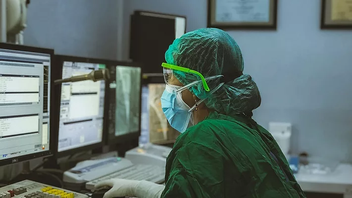 Healthcare worker wearing PPE using a computer