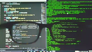 Glasses in front of coding on screen Glasses in front of coding on screen