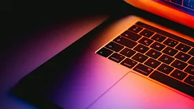 Open laptop with pink, orange, and purple lighting