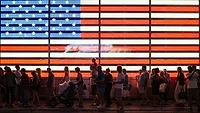 American flag lit with people
