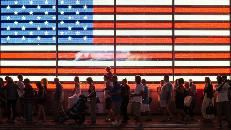 American flag lit with people