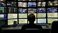Man in front of monitors Man in front of monitors