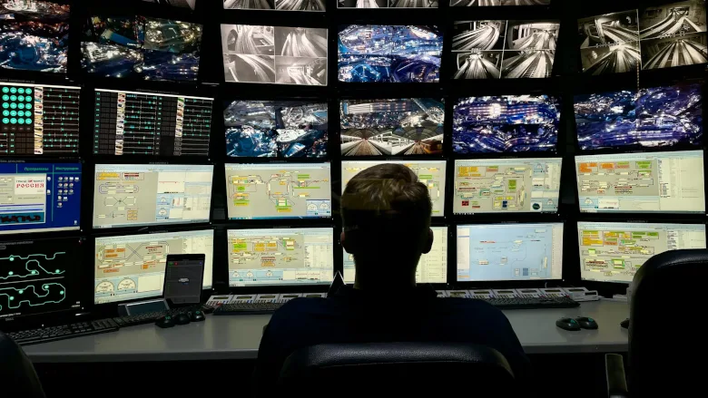 Man in front of monitors