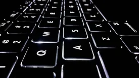 Black laptop keyboard with white lighting
