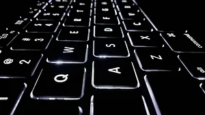 Black laptop keyboard with white lighting