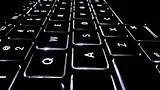 Black laptop keyboard with white lighting
