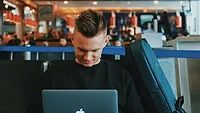Man on laptop at airport