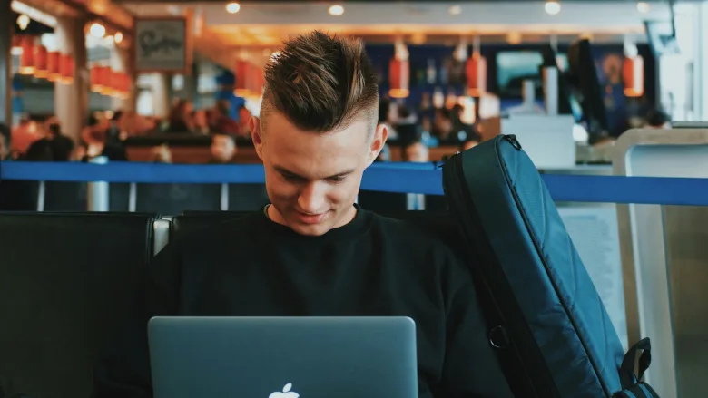 Man on laptop at airport
