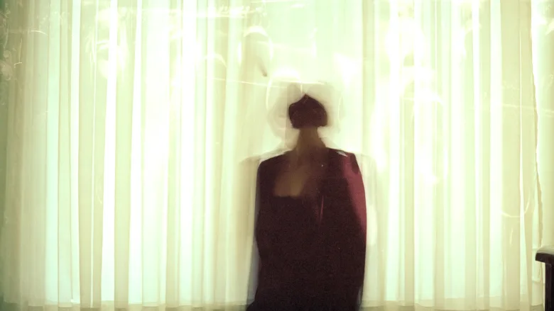 Blurry person behind curtain 