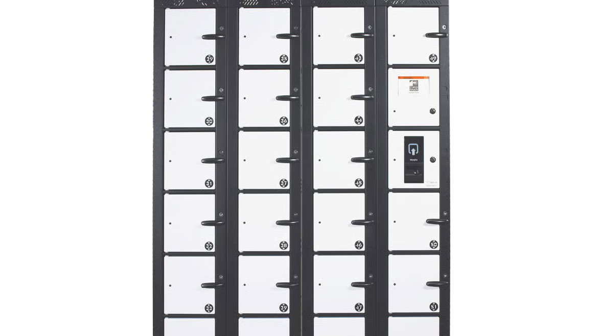 A black locker bank with many white, numbered compartments, some with handles, one featuring a scanner.