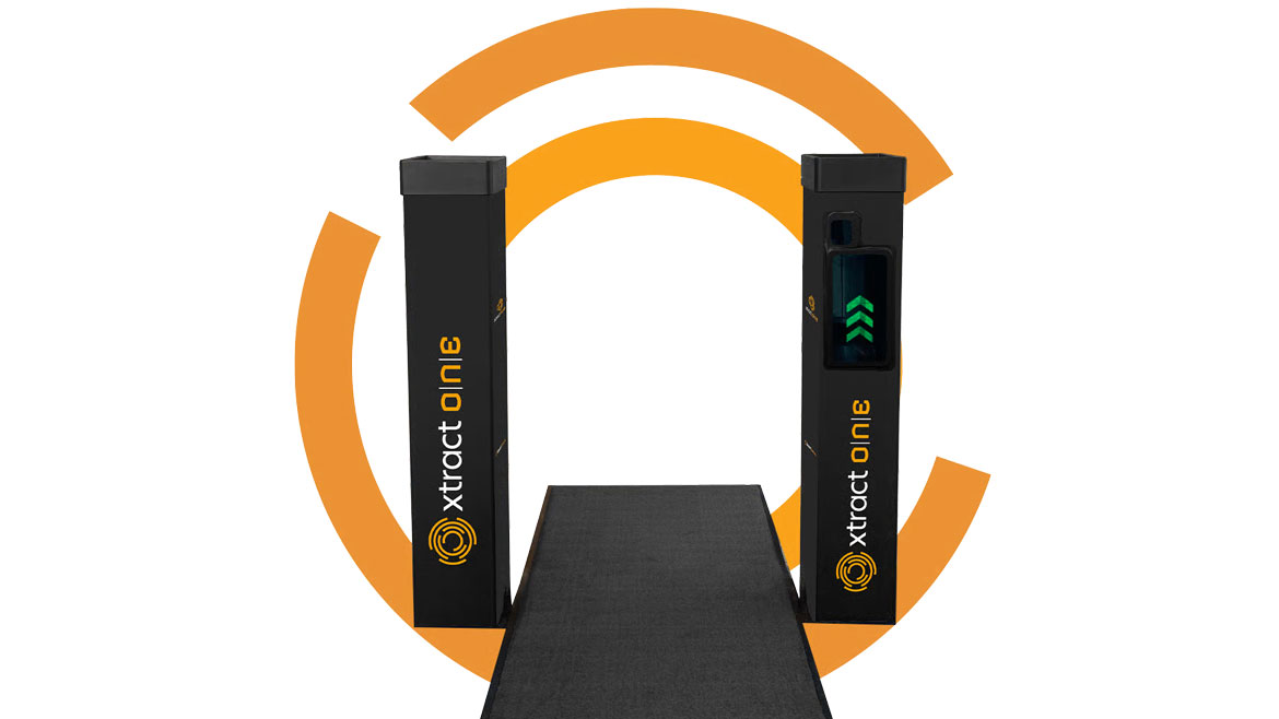Two black Xtract One security gates frame a walkway, one with a green arrow.