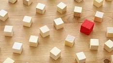 One red block in a group of white blocks