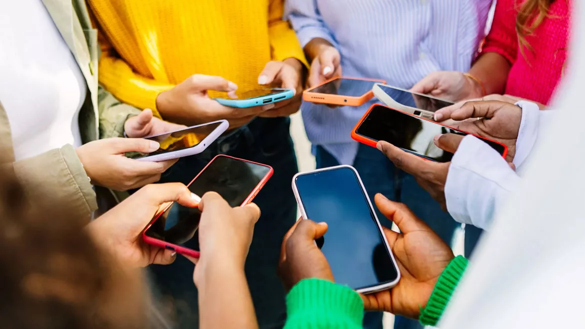 group of people standing in circle using cellphones