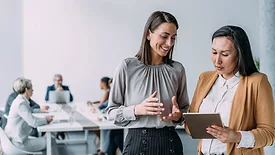 Two women consulting with a group in background