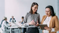 Two women consulting with a group in background