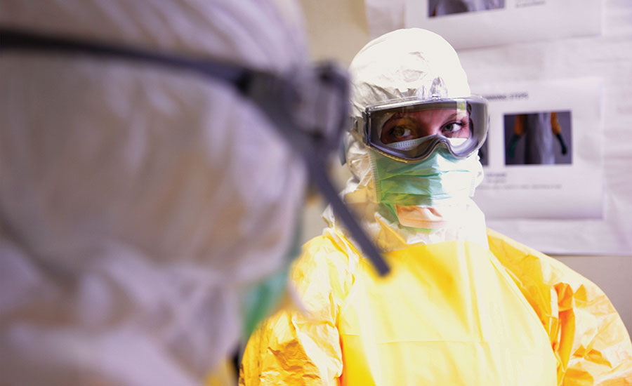Here, a CDC healthcare worker takes the proper measurements to ensure that she is protected in an Ebola clinic in West Africa. - Security Magazine