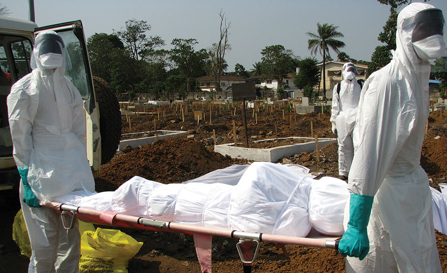 Here, CDC emergency healthcare workers take extreme precautions to properly bury a body in a local cemetery in Sierra Leone during Ebola outbreak. - Security Magazine